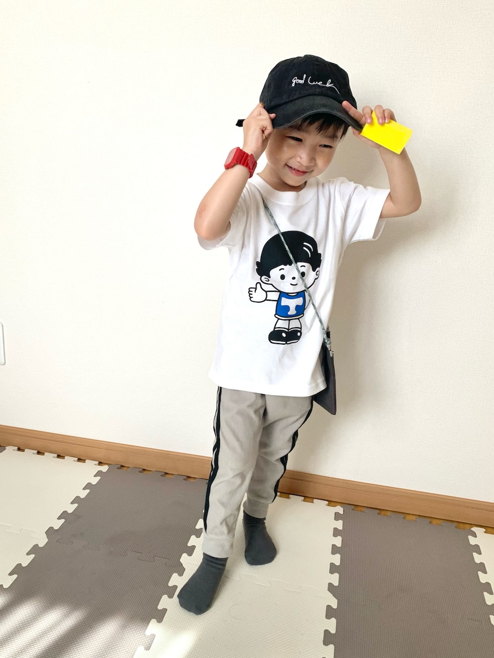 グレー系のその他パンツ、ホワイト系のTシャツ/カットソー、ブラウン系のショルダーバッグを着用したキッズの春コーディネートの3枚目の写真