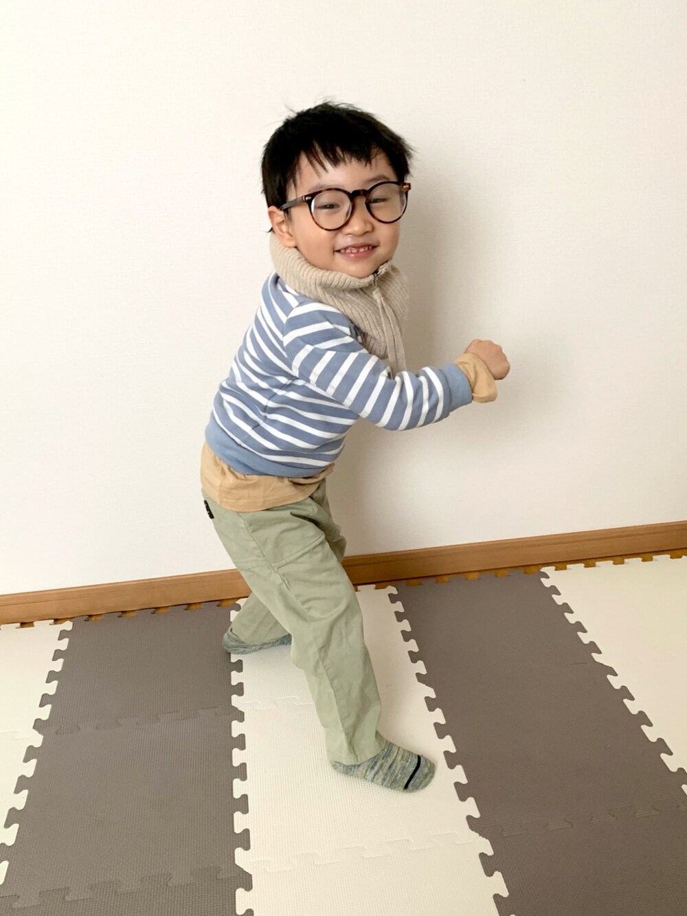グリーン系のチノパンツ、ブルー系のスウェット、ベージュ系のTシャツ/カットソーを着用したキッズの冬コーディネートの2枚目の写真