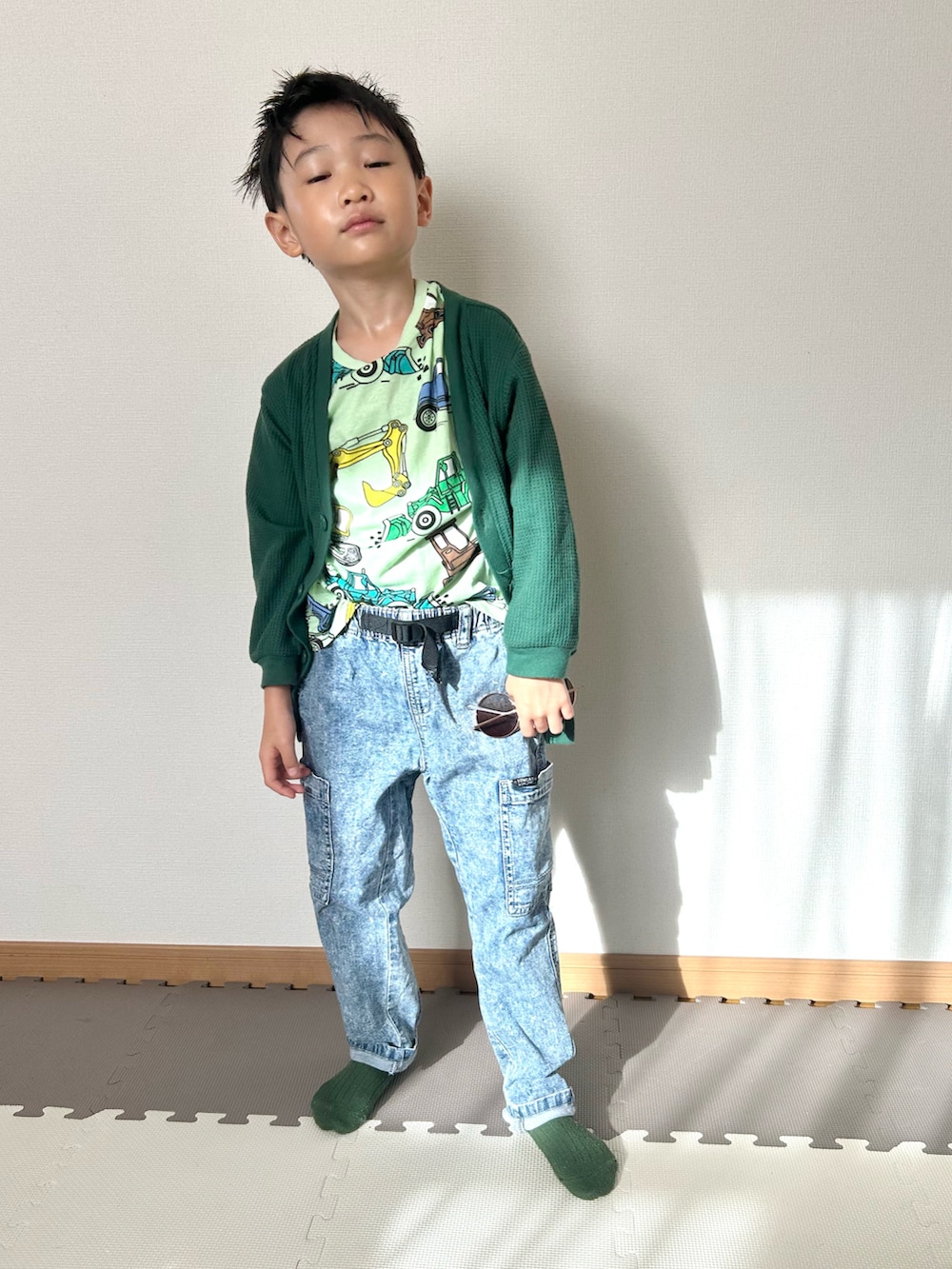 グリーン系のカーディガン/ボレロ、グリーン系のTシャツ/カットソー、ブルー系のパンツを着用したキッズの秋コーディネートの2枚目の写真