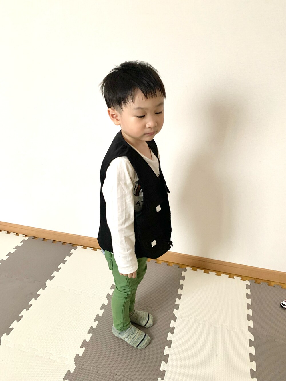 ブラック系のベスト、グリーン系のその他パンツ、ホワイト系のTシャツ/カットソーを着用したキッズの春コーディネートの4枚目の写真