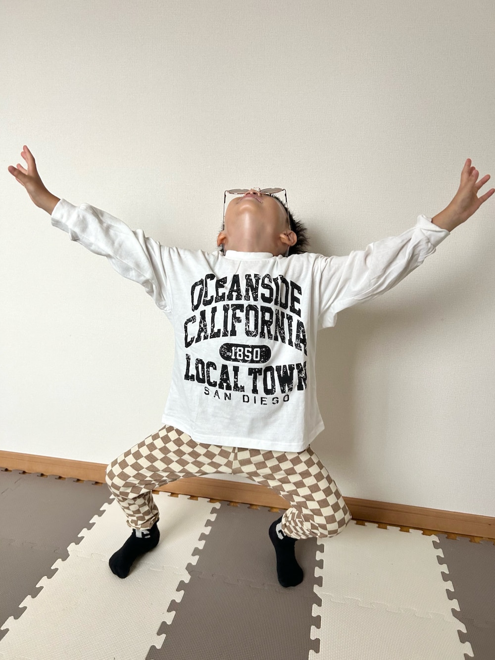 ブラウン系のその他パンツ、ホワイト系のTシャツ/カットソー、ブラウン系のサングラスを着用したキッズの秋コーディネートの4枚目の写真