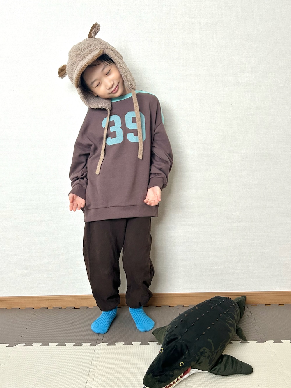 ブラウン系のスウェット、ブラウン系のスウェットパンツ、ブラウン系の帽子を着用したキッズの冬コーディネートの4枚目の写真