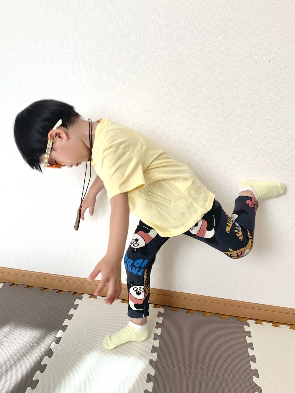 イエロー系のTシャツ/カットソー、グレー系のスウェットパンツ、オレンジ系のサングラスを着用したキッズの夏コーディネートの2枚目の写真