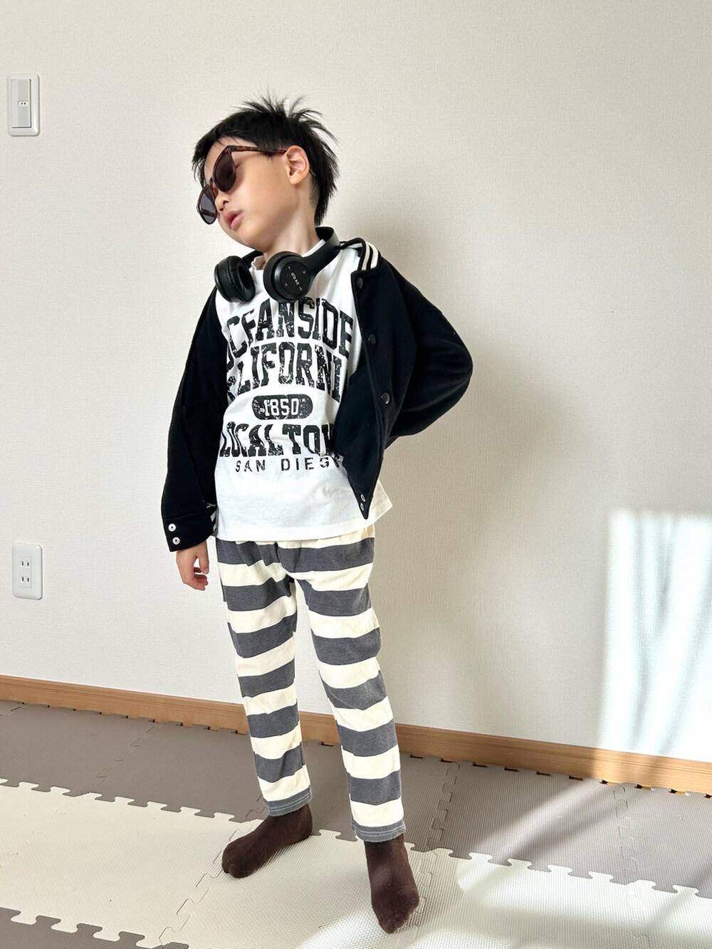 グレー系のその他パンツ、ホワイト系のTシャツ/カットソー、ブラック系のジャケット/アウターを着用したキッズの秋コーディネートの3枚目の写真