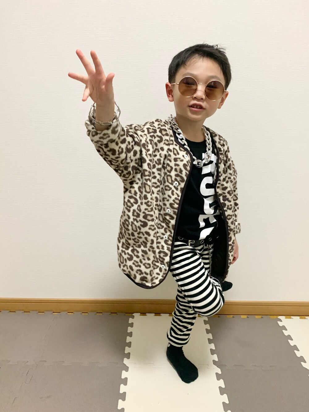ベージュ系のカーディガン/ボレロ、ホワイト系のパンツ、ブラック系のTシャツ/カットソーを着用したキッズの冬コーディネートの2枚目の写真