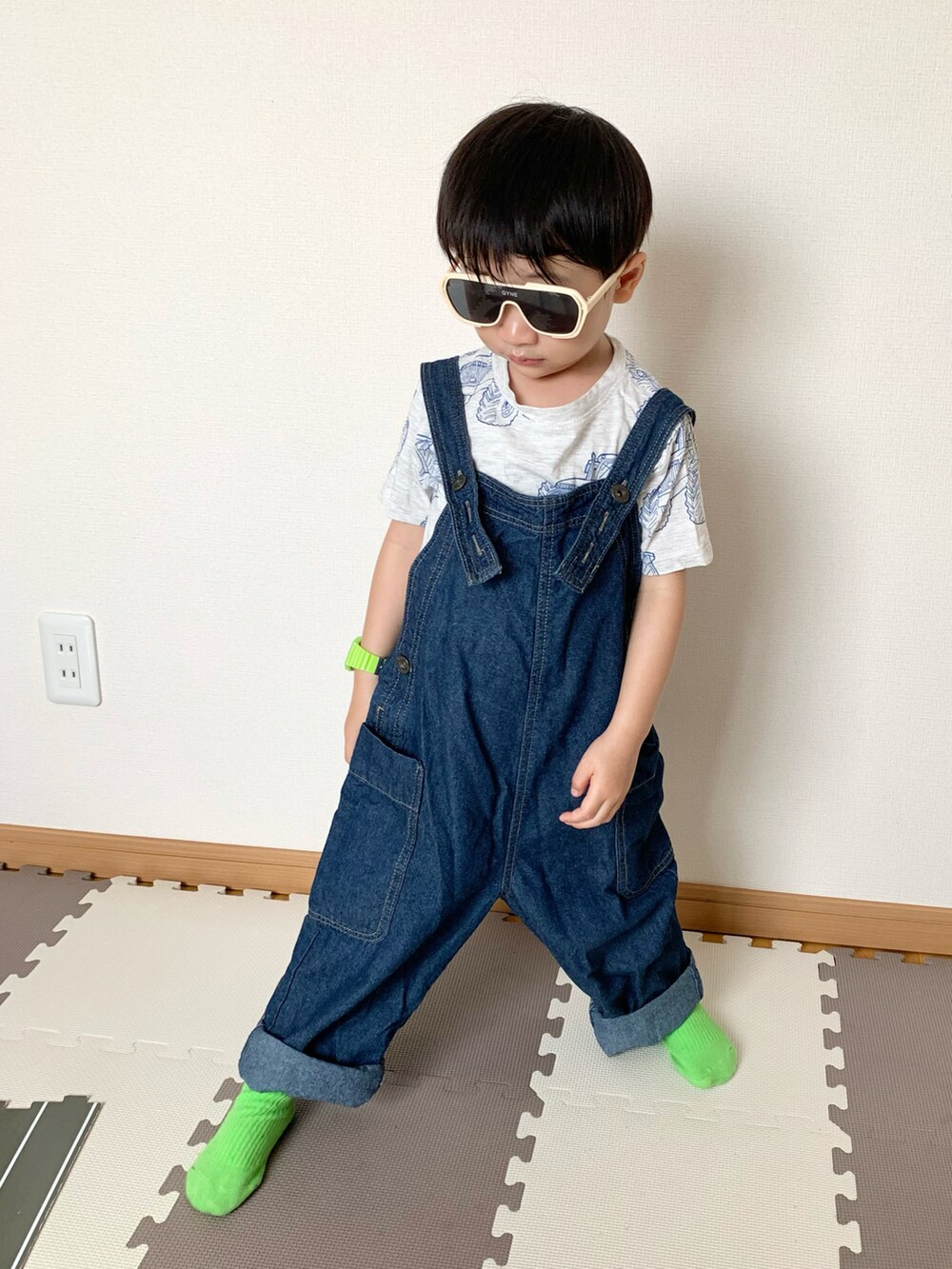 ブルー系のサロペット/オーバーオール、グレー系のTシャツ/カットソー、ホワイト系のサングラスを着用したキッズの春コーディネートの3枚目の写真