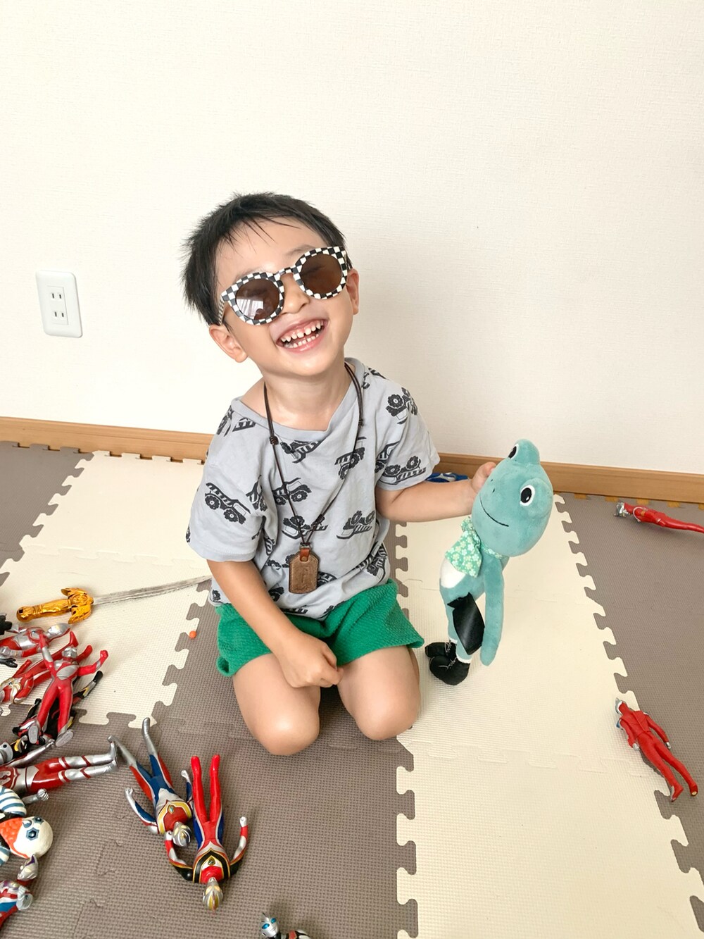 グリーン系のパンツ、グレー系のTシャツ/カットソー、ブラウン系のネックレスを着用したキッズの夏コーディネートの5枚目の写真