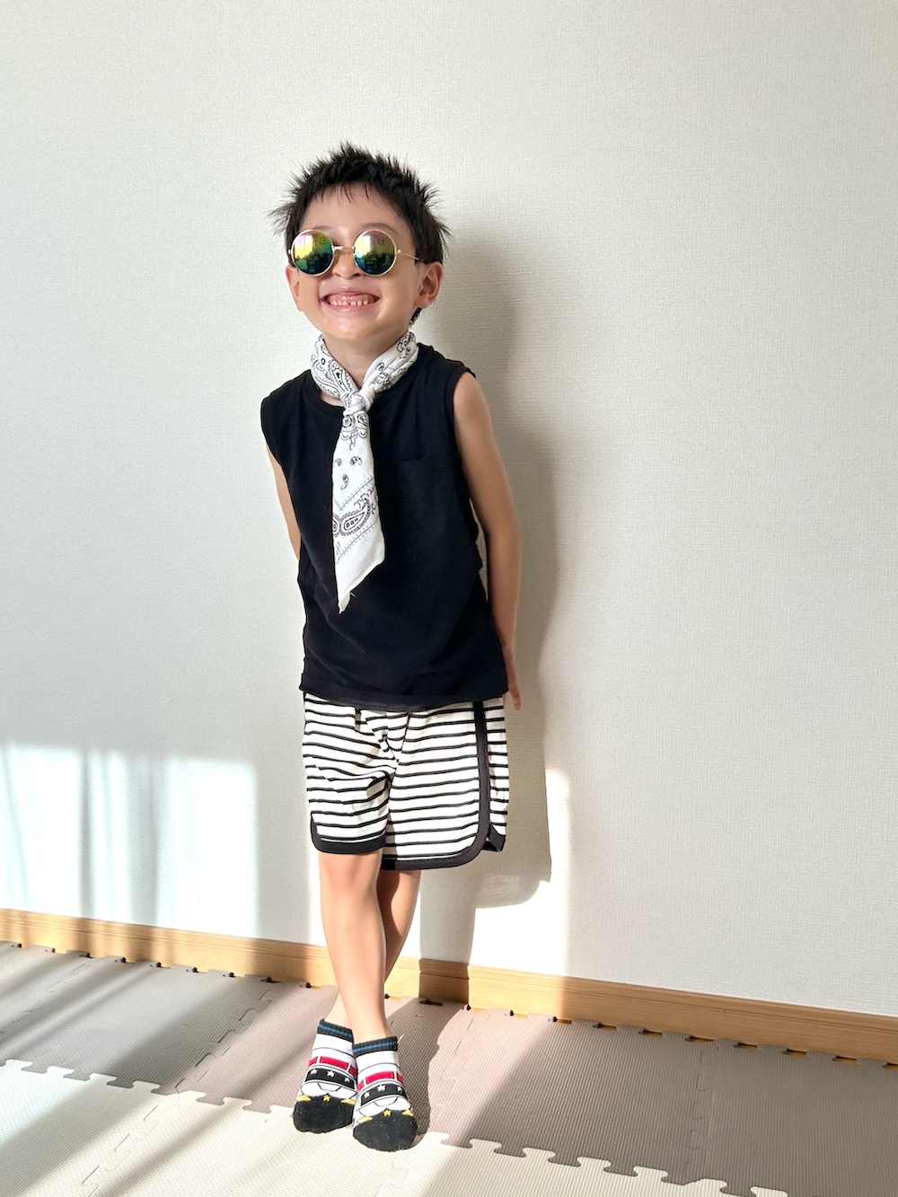 ホワイト系のセットアップ、ブラック系のタンクトップ、ホワイト系のソックス/靴下を着用したキッズの夏コーディネートの2枚目の写真