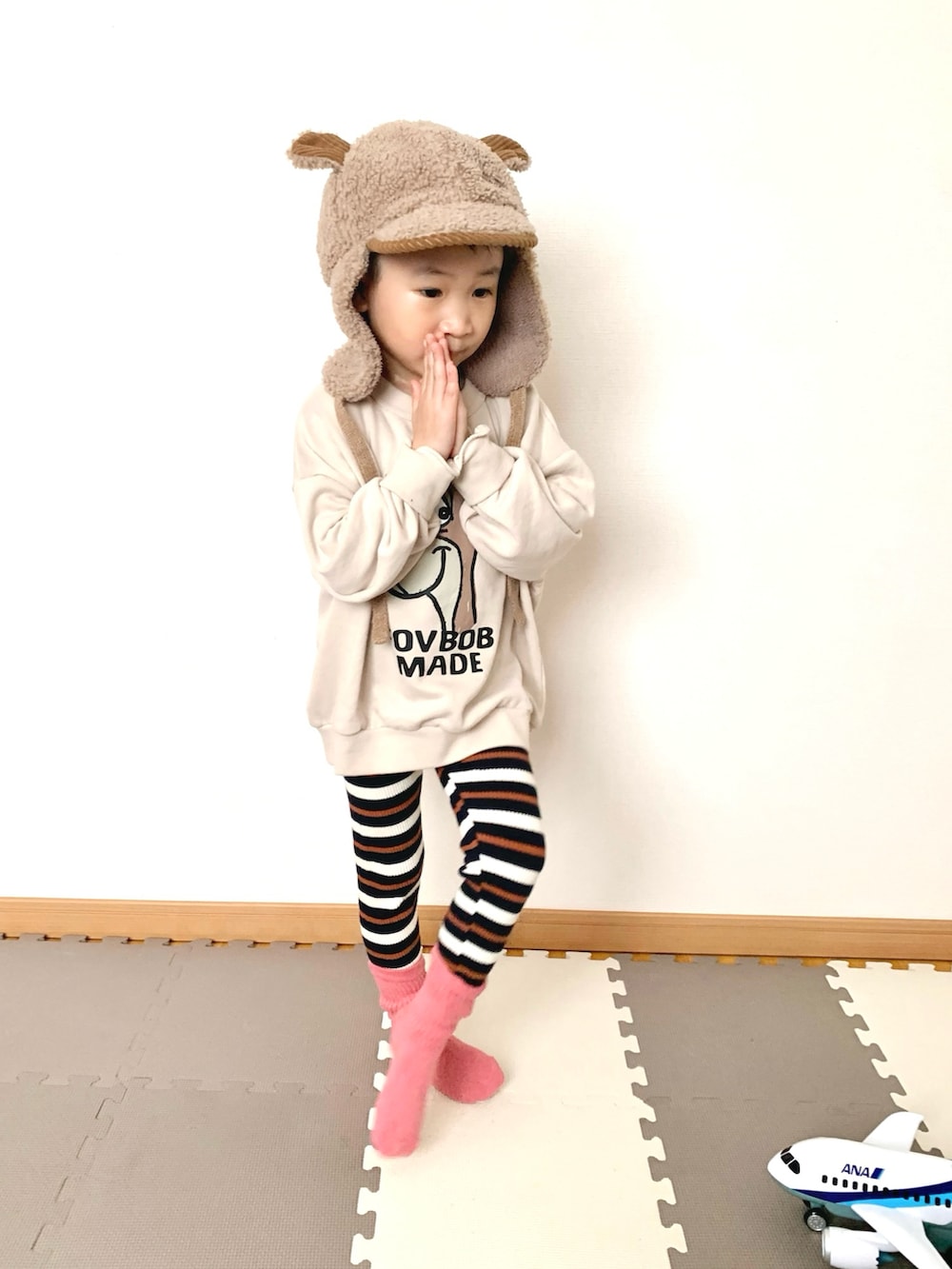 ホワイト系のスウェット、ブルー系のその他パンツ、ブラウン系の帽子を着用したキッズの冬コーディネートの4枚目の写真