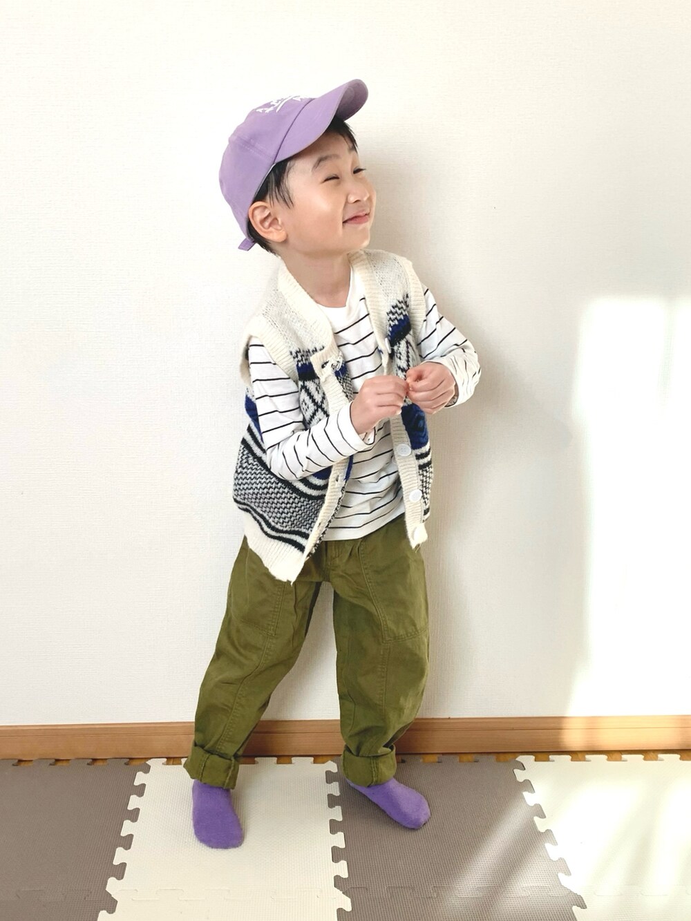 ホワイト系のベスト、ホワイト系のTシャツ/カットソー、グリーン系のパンツを着用したキッズの冬コーディネートの4枚目の写真