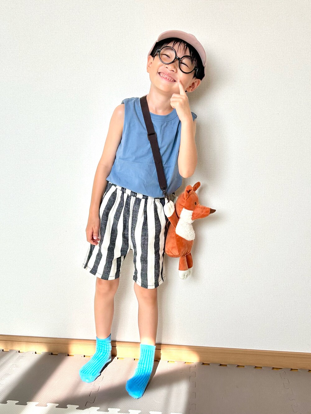 ブルー系のタンクトップ、ホワイト系のパンツ、ブラウン系のショルダーバッグを着用したキッズの夏コーディネートの4枚目の写真