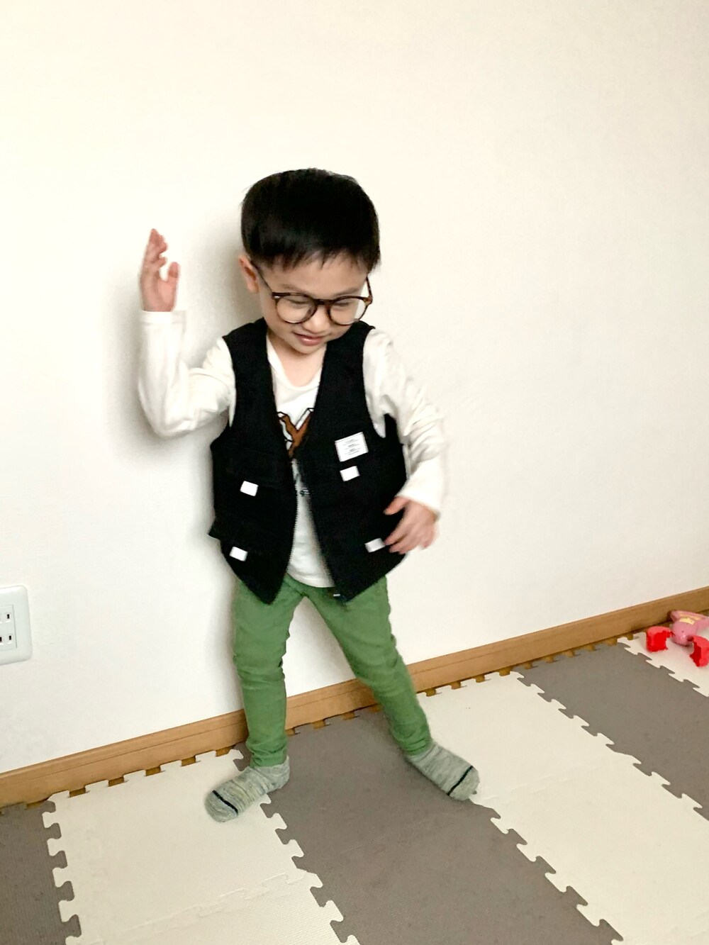 ブラック系のベスト、グリーン系のその他パンツ、ホワイト系のTシャツ/カットソーを着用したキッズの春コーディネートの2枚目の写真