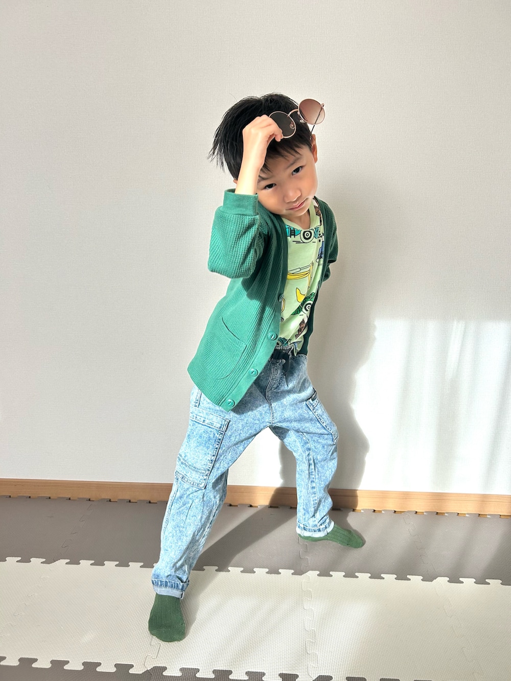 グリーン系のカーディガン/ボレロ、グリーン系のTシャツ/カットソー、ブルー系のパンツを着用したキッズの秋コーディネートの4枚目の写真