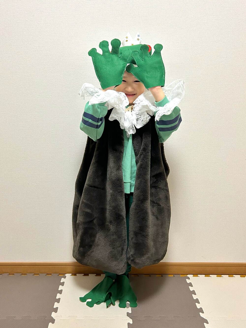 ブラウン系のベスト、グリーン系のスウェット、ホワイト系のスウェットパンツを着用したキッズの冬コーディネートの5枚目の写真