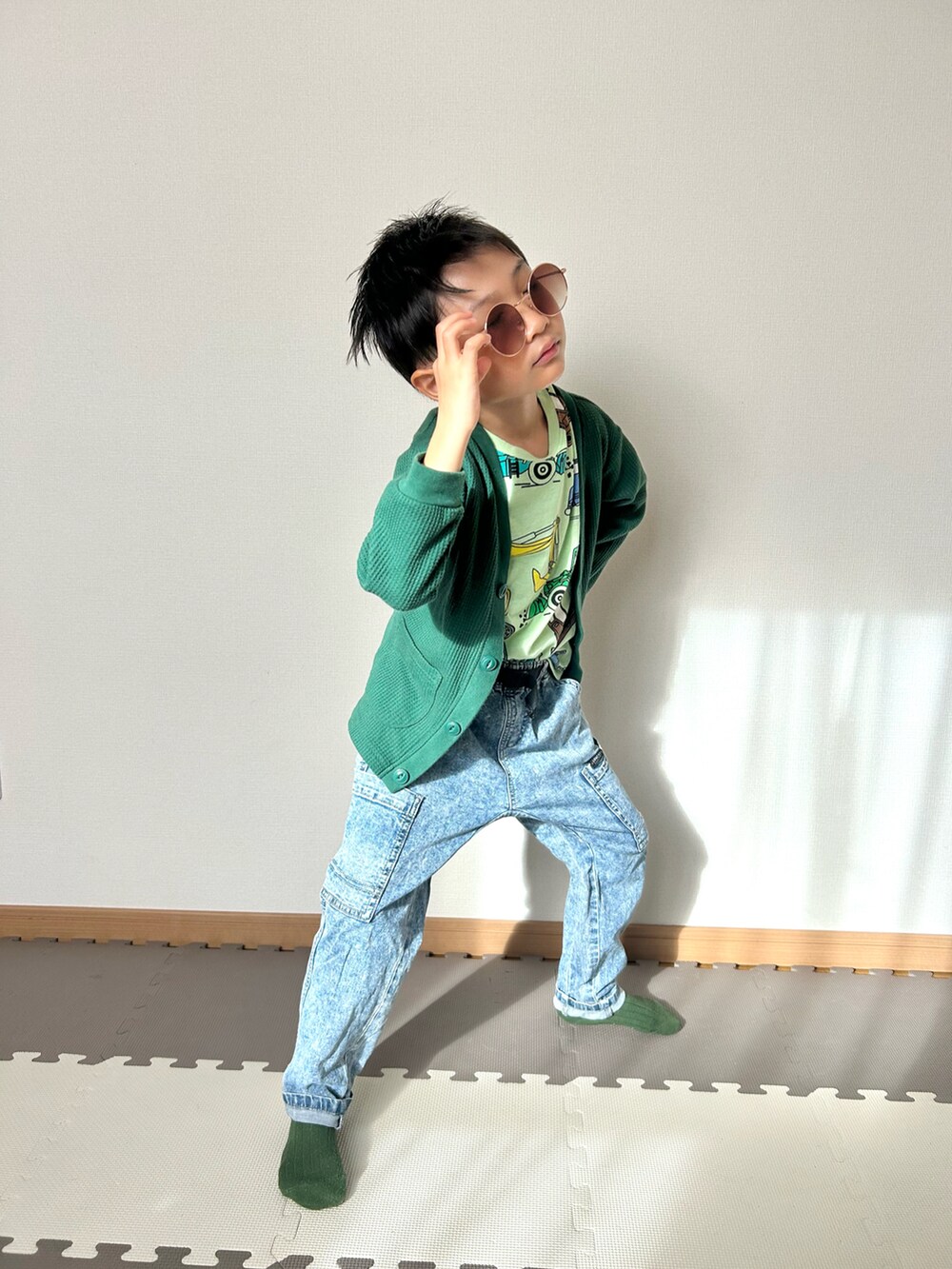 グリーン系のカーディガン/ボレロ、グリーン系のTシャツ/カットソー、ブルー系のパンツを着用したキッズの秋コーディネートの3枚目の写真