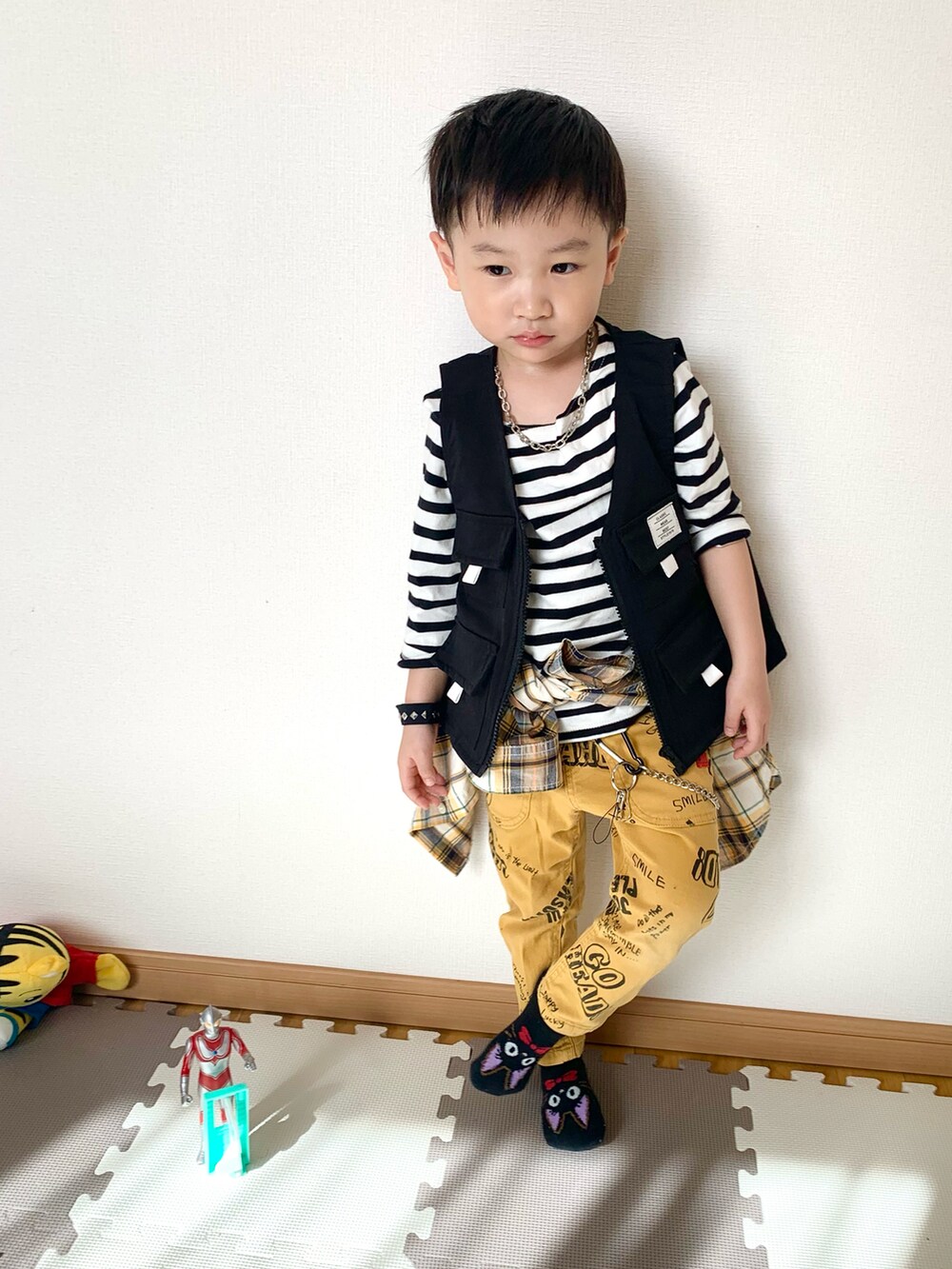 ブラック系のベスト、ホワイト系のTシャツ/カットソー、イエロー系のその他パンツを着用したキッズの春コーディネートの4枚目の写真