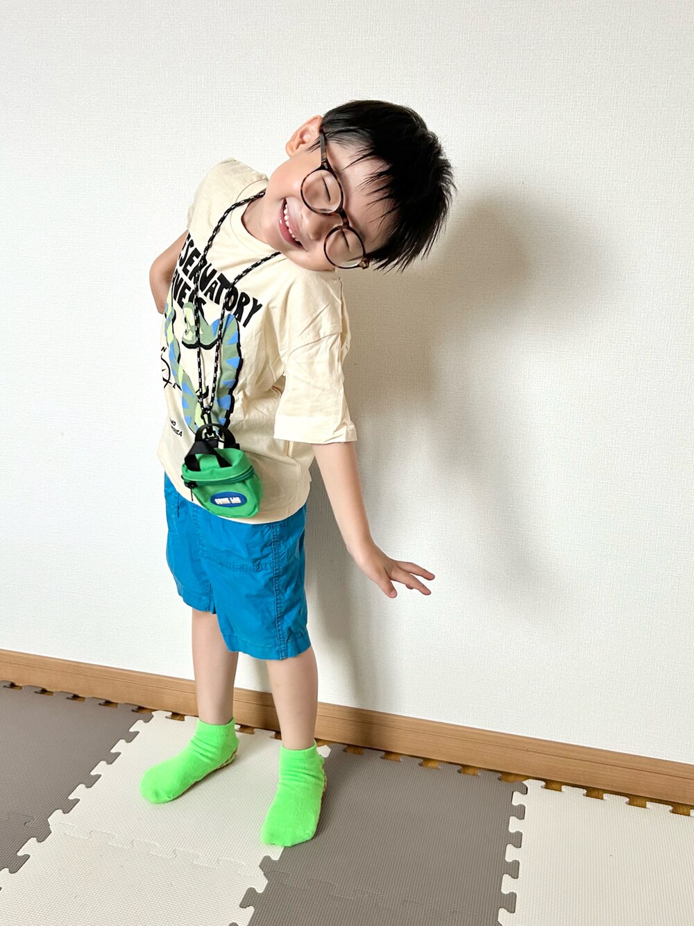 ブルー系のパンツ、ベージュ系のTシャツ/カットソー、グリーン系のバッグを着用したキッズの夏コーディネートの3枚目の写真