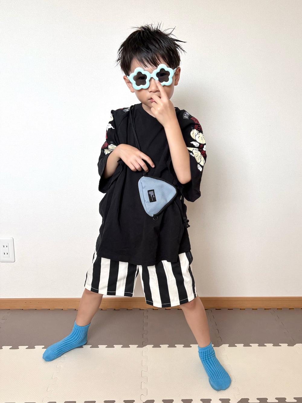 ブラック系のTシャツ/カットソー、ホワイト系のパンツ、ブルー系のサングラスを着用したキッズの夏コーディネートの3枚目の写真