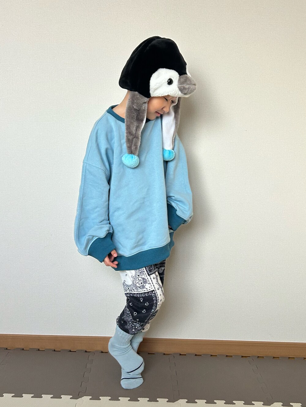 ブルー系のスウェット、ブルー系のスウェットパンツ、ブラック系の帽子を着用したキッズの秋コーディネートの3枚目の写真
