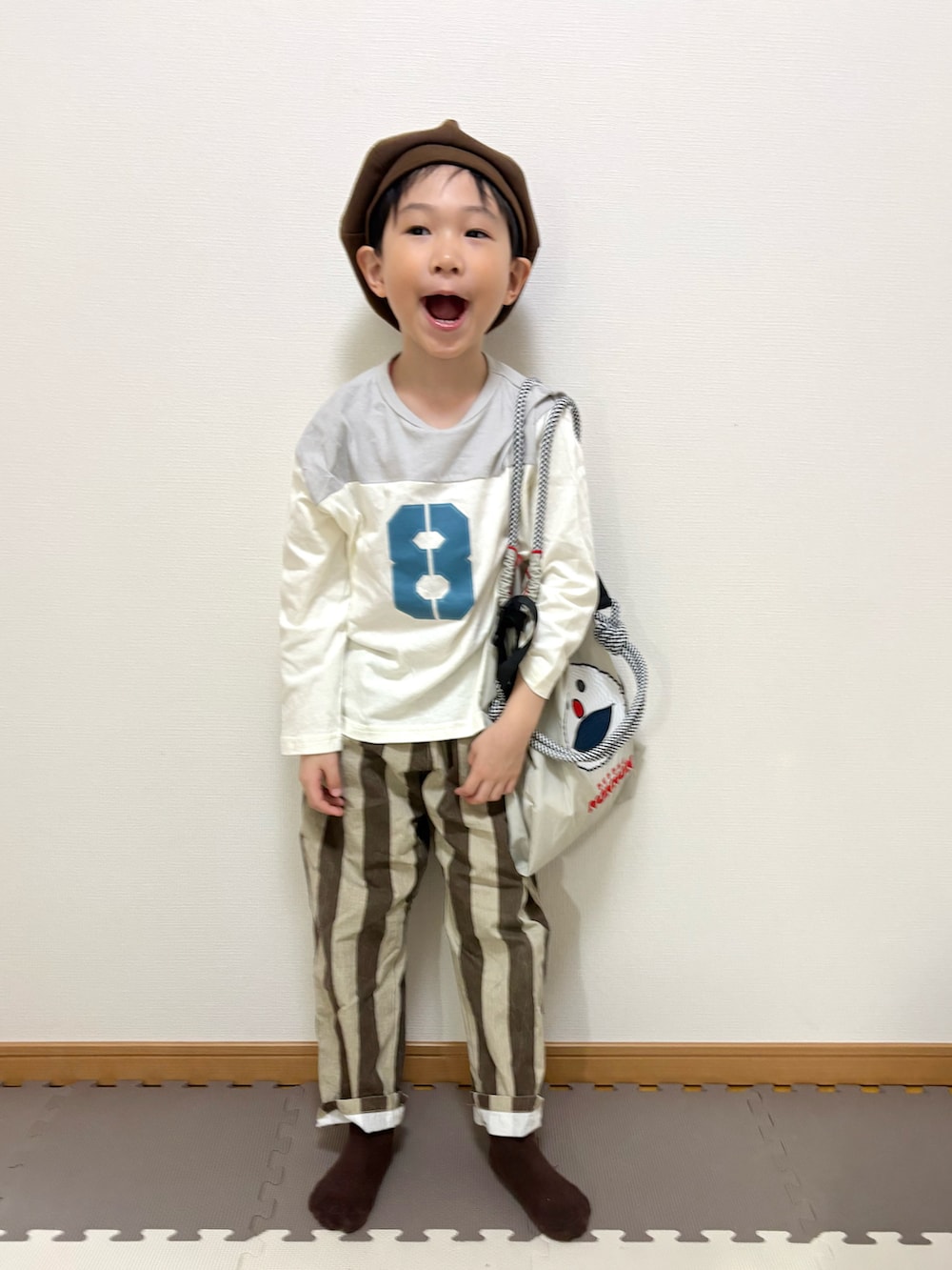 グレー系のTシャツ/カットソー、ブラウン系のその他パンツ、ベージュ系のトートバッグを着用したキッズの春コーディネートの4枚目の写真