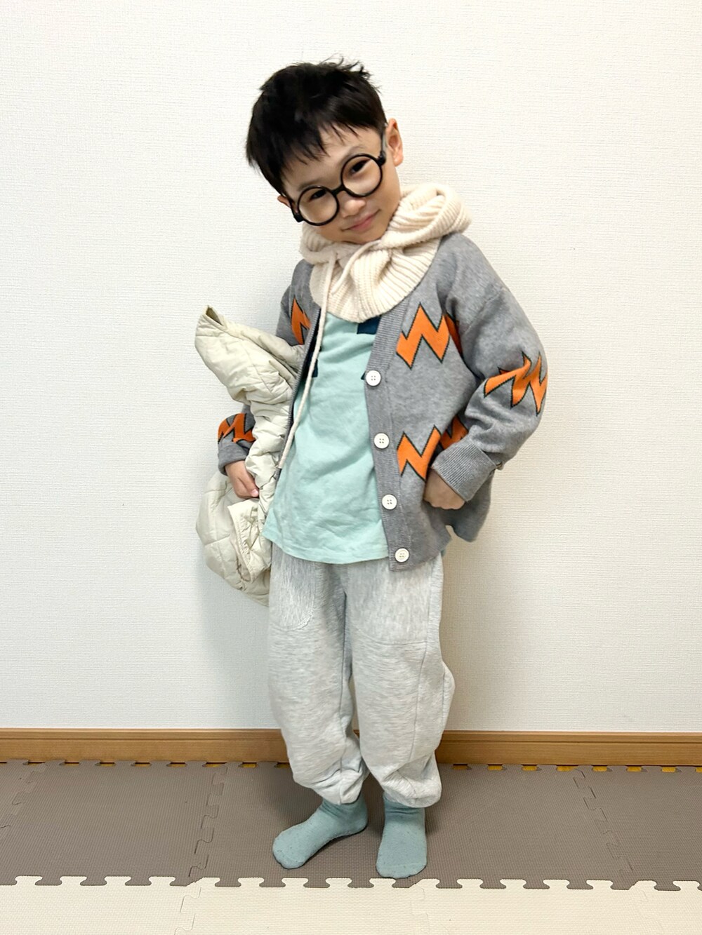 グレー系のカーディガン/ボレロ、ブルー系のTシャツ/カットソー、グレー系のスウェットパンツを着用したキッズの冬コーディネートの3枚目の写真
