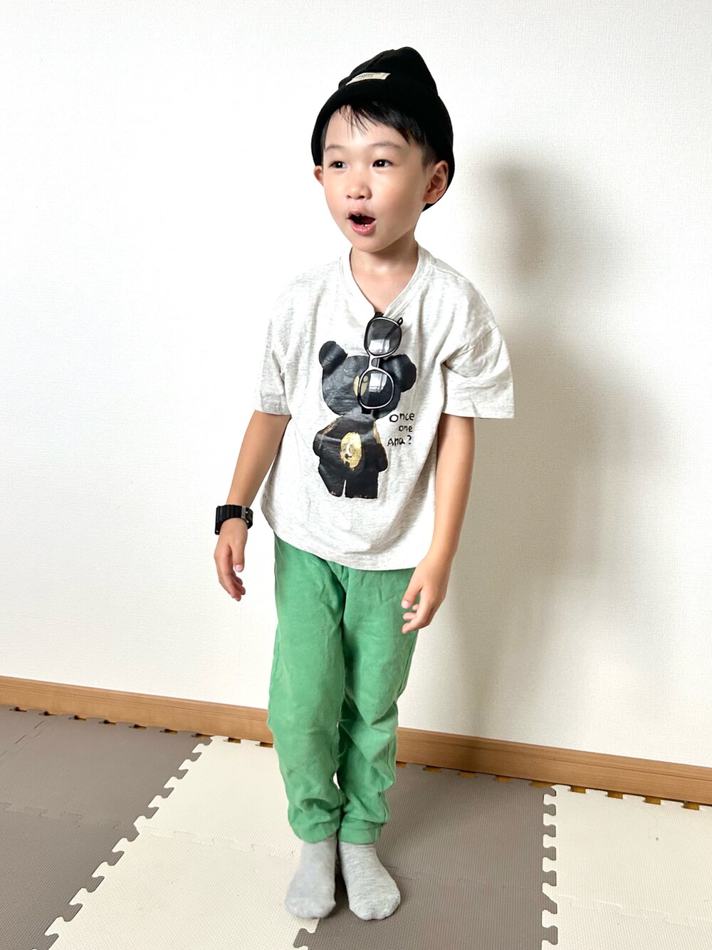 グリーン系のスウェットパンツ、グレー系のTシャツ/カットソー、ブラック系のサングラスを着用したキッズの秋コーディネートの2枚目の写真