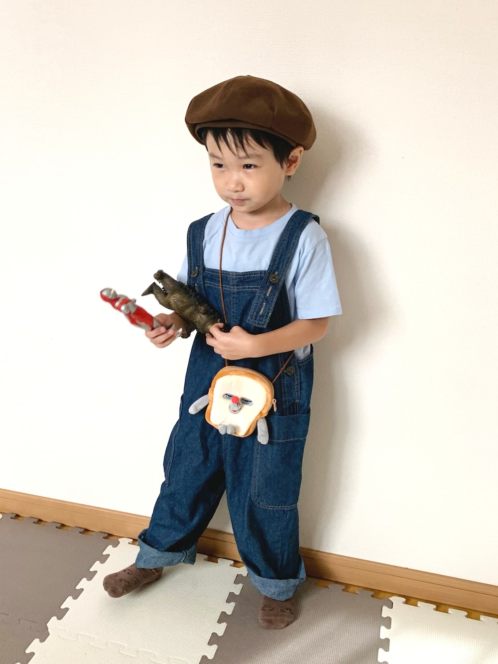 ブルー系のサロペット/オーバーオール、ブラウン系のショルダーバッグ、ブルー系のTシャツ/カットソーを着用したキッズの秋コーディネートの2枚目の写真