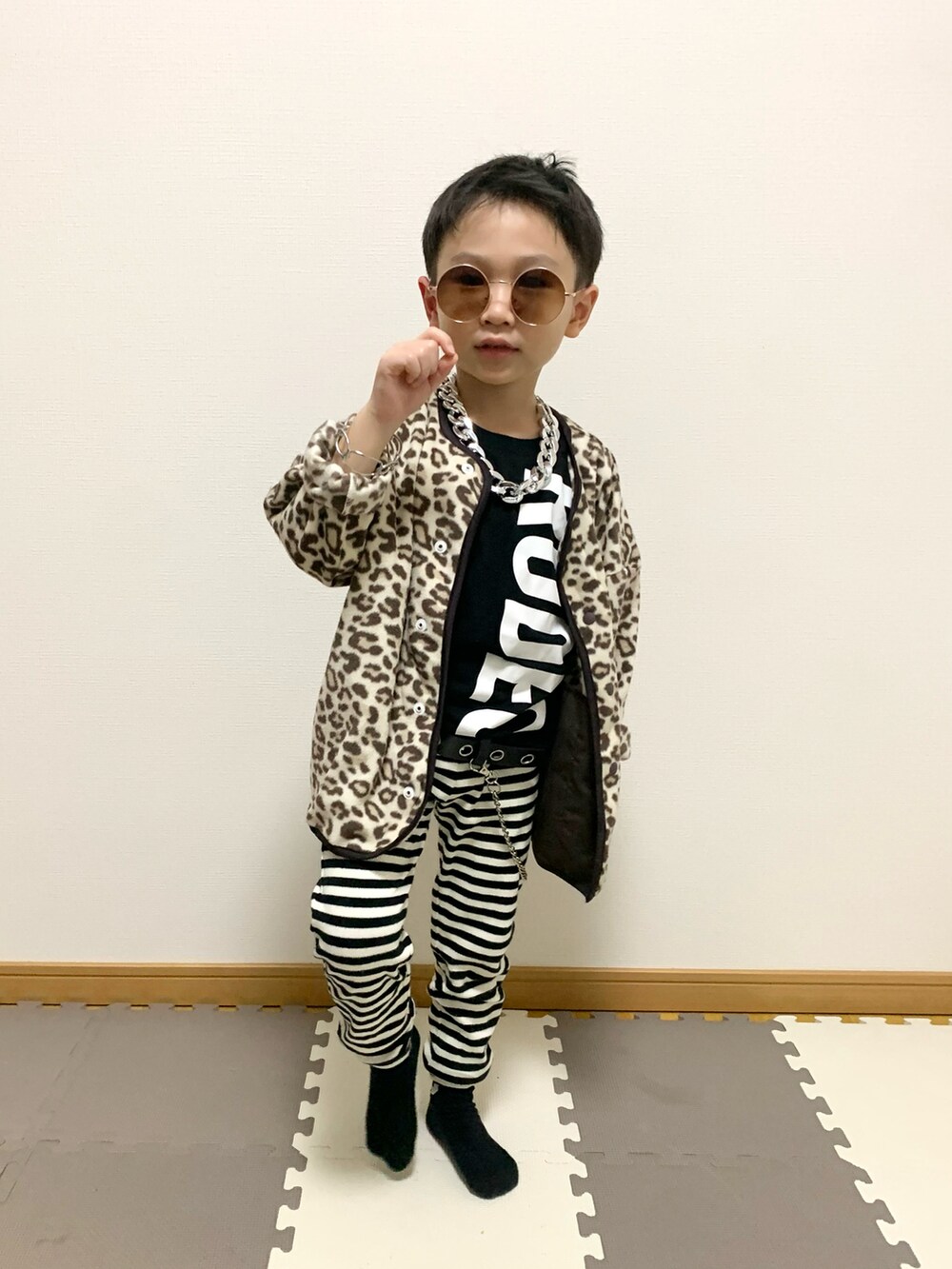 ベージュ系のカーディガン/ボレロ、ホワイト系のパンツ、ブラック系のTシャツ/カットソーを着用したキッズの冬コーディネートの3枚目の写真