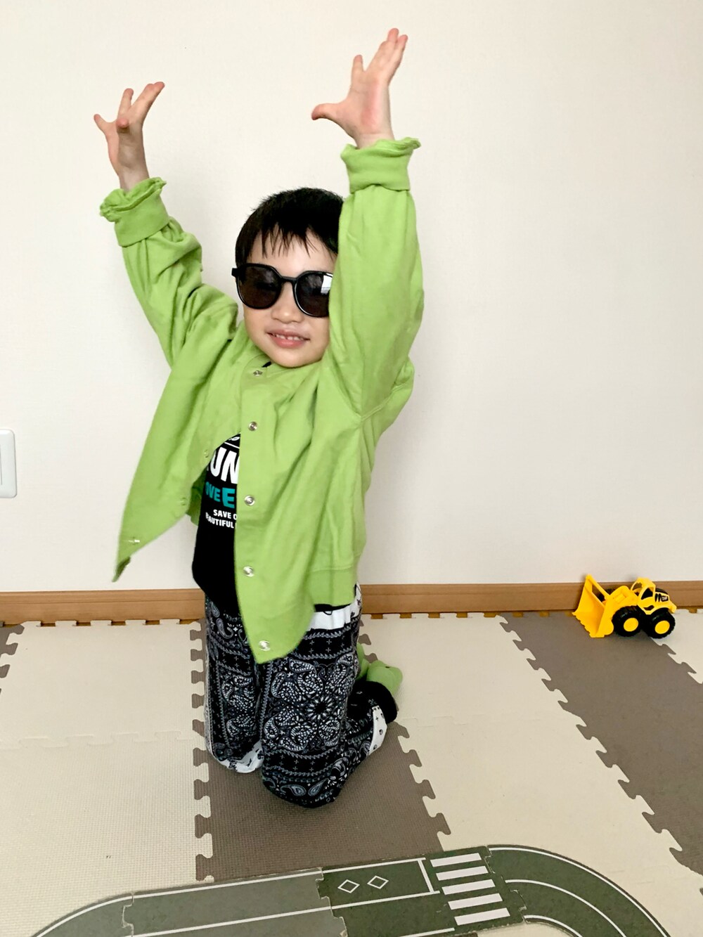 グリーン系のカーディガン/ボレロ、ブラック系のTシャツ/カットソー、ブルー系のスウェットパンツを着用したキッズの春コーディネートの3枚目の写真
