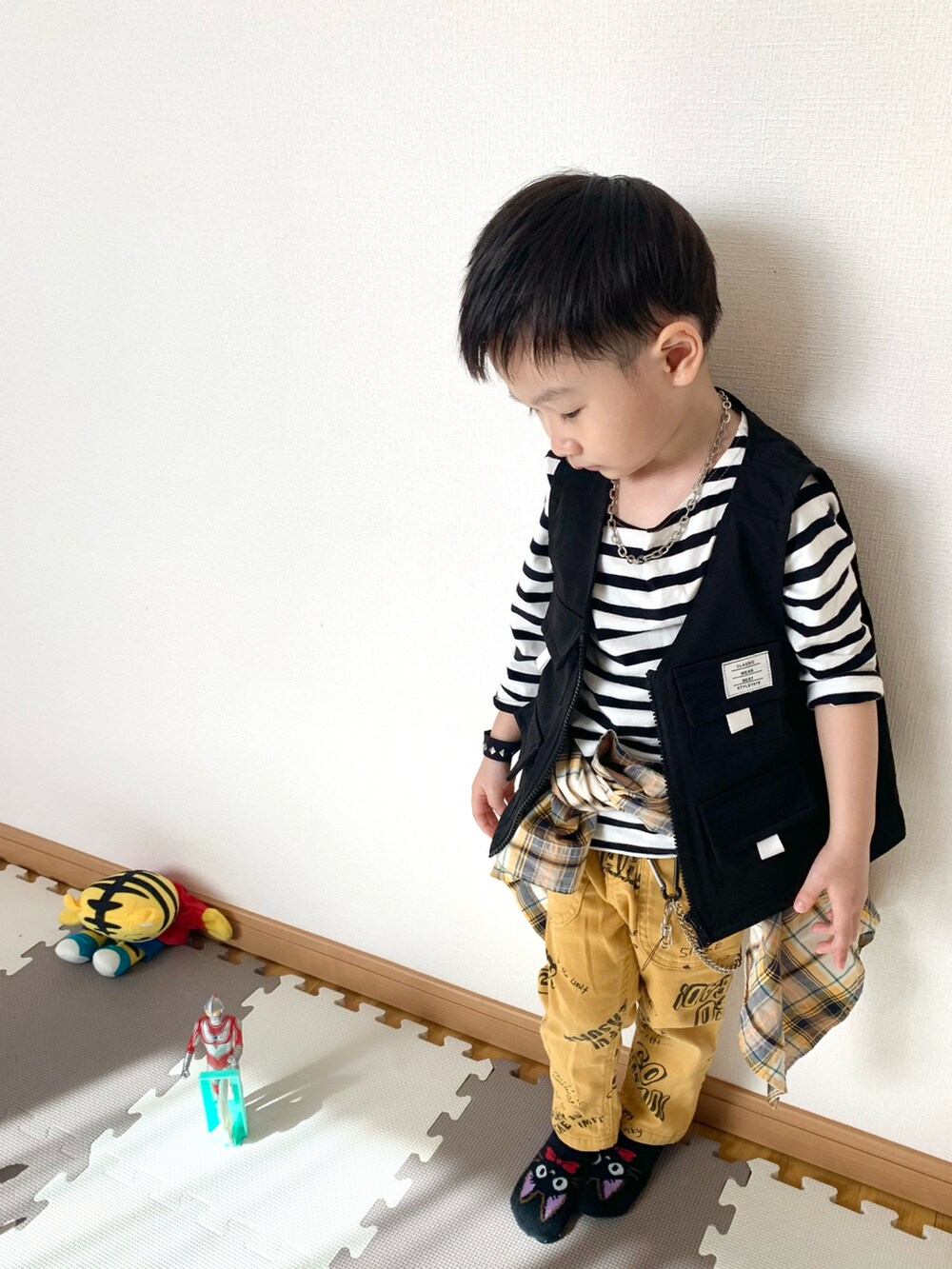 ブラック系のベスト、ホワイト系のTシャツ/カットソー、イエロー系のその他パンツを着用したキッズの春コーディネートの3枚目の写真