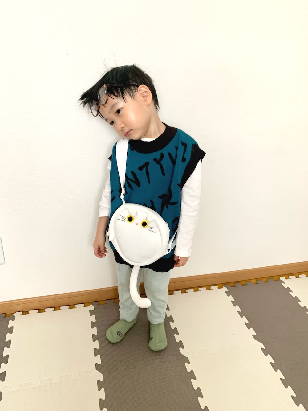 ブルー系のベスト、ホワイト系のTシャツ/カットソー、グリーン系のスウェットパンツを着用したキッズの春コーディネートの4枚目の写真