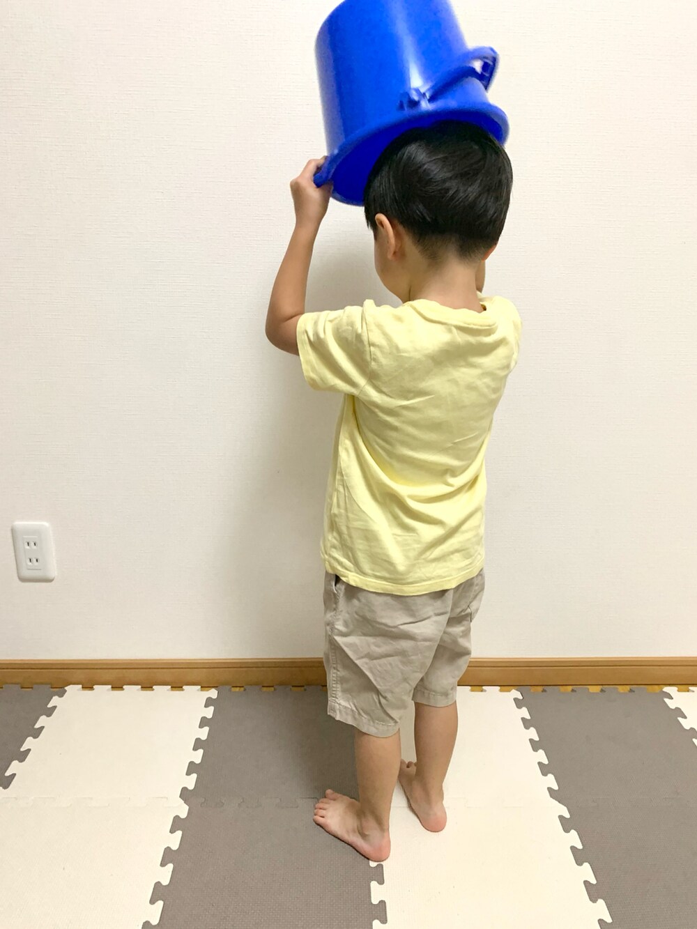 イエロー系のTシャツ/カットソー、ベージュ系のチノパンツ、ブルー系のランドリーグッズを着用したキッズの秋コーディネートの5枚目の写真