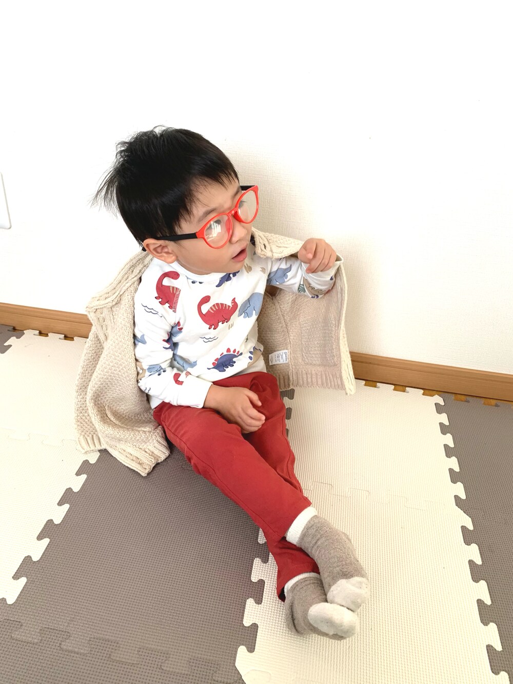 ホワイト系のカーディガン/ボレロ、ホワイト系のスウェット、レッド系のチノパンツを着用したキッズの秋コーディネートの2枚目の写真