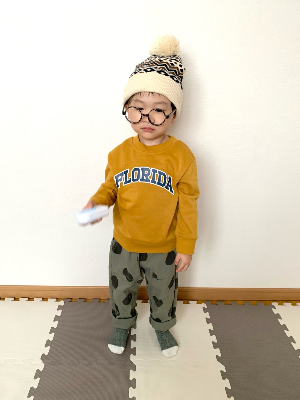 イエロー系のスウェット、グリーン系のその他パンツ、ホワイト系のニットキャップ/ビーニーを着用したキッズの秋コーディネートの4枚目の写真