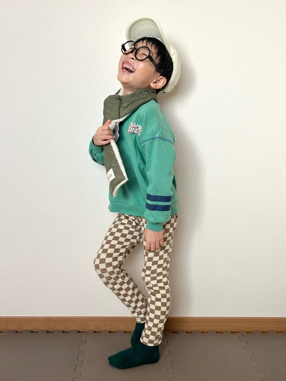 ブラウン系のその他パンツ、グリーン系のスウェット、ホワイト系のキャップを着用したキッズの冬コーディネートの2枚目の写真