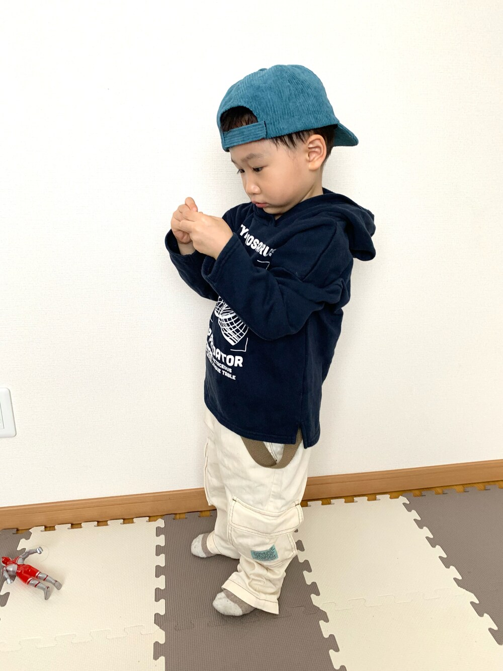 ブルー系のパーカー、ホワイト系のサロペット/オーバーオール、ブルー系のキャップを着用したキッズの冬コーディネートの3枚目の写真