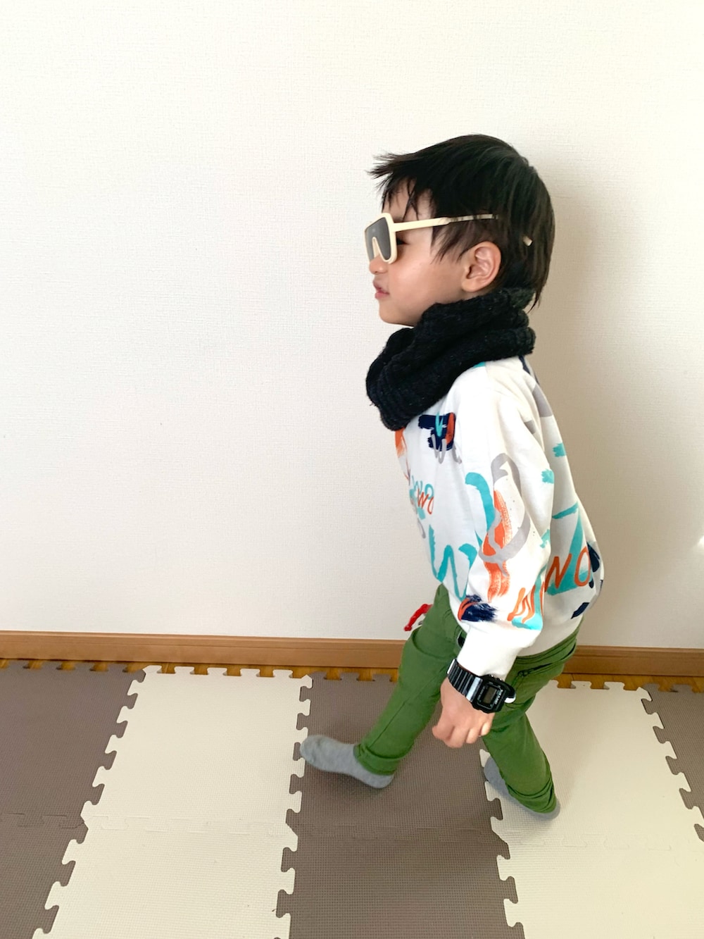 ホワイト系のスウェット、グリーン系のその他パンツ、ホワイト系のサングラスを着用したキッズの冬コーディネートの3枚目の写真