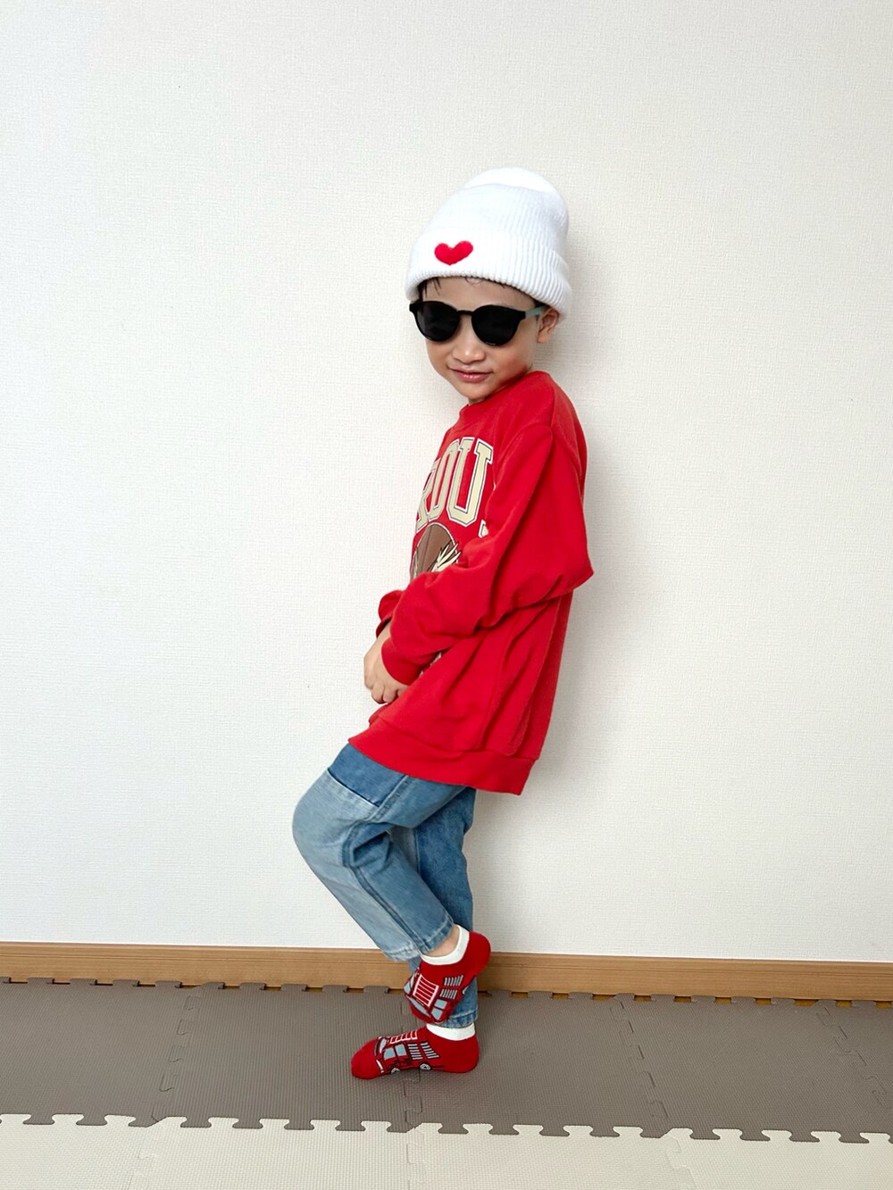 ブルー系のデニムパンツ、レッド系のスウェット、ホワイト系のニットキャップ/ビーニーを着用したキッズの冬コーディネートの5枚目の写真