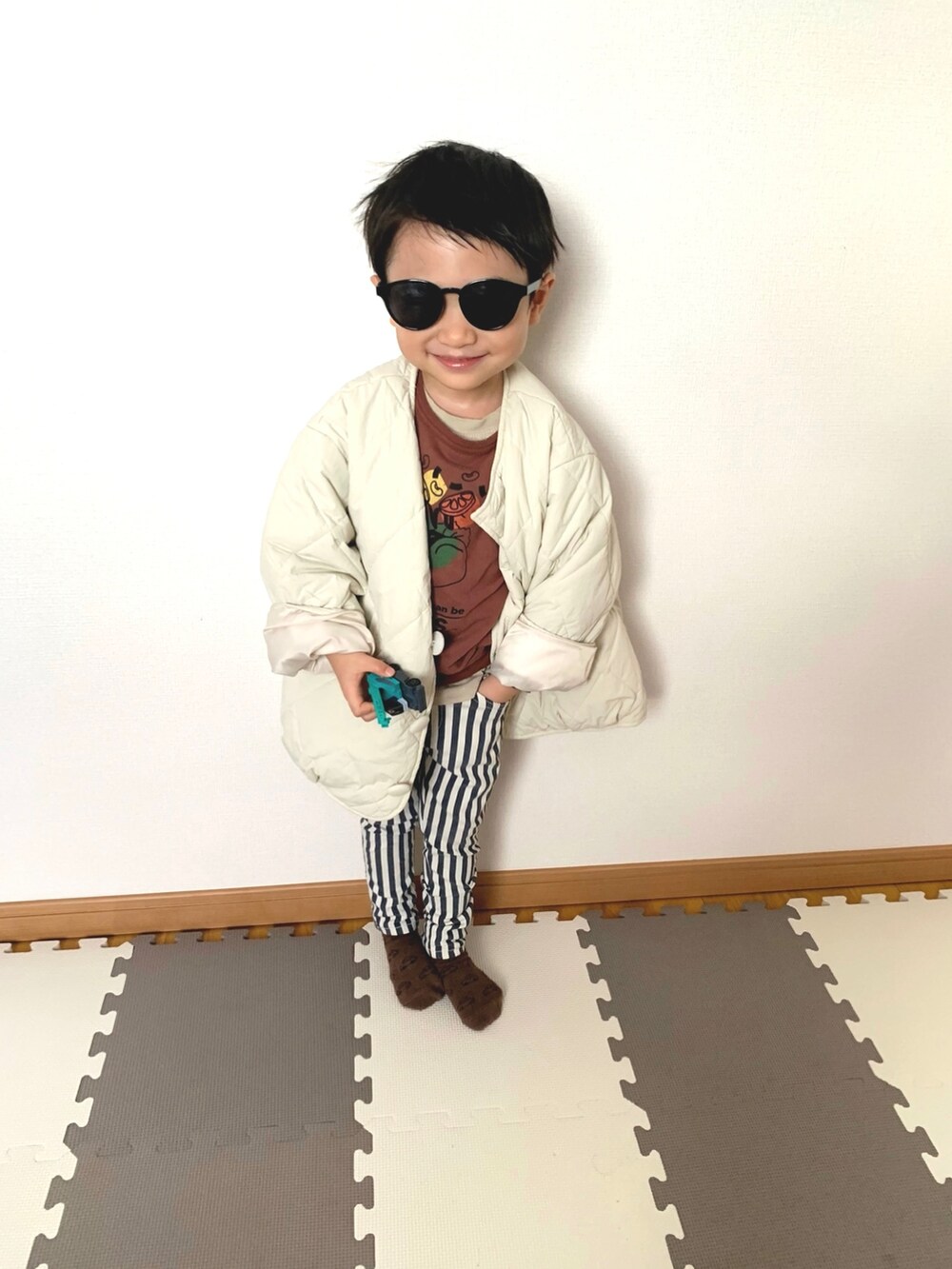 ブルー系のチノパンツ、ブラウン系のスウェット、ホワイト系のブルゾンを着用したキッズの冬コーディネートの3枚目の写真