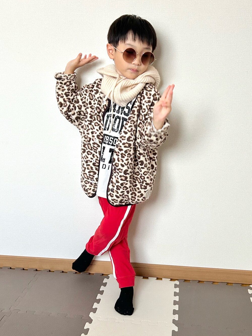 レッド系のスウェットパンツ、ベージュ系のカーディガン/ボレロ、ホワイト系のTシャツ/カットソーを着用したキッズの秋コーディネートの2枚目の写真