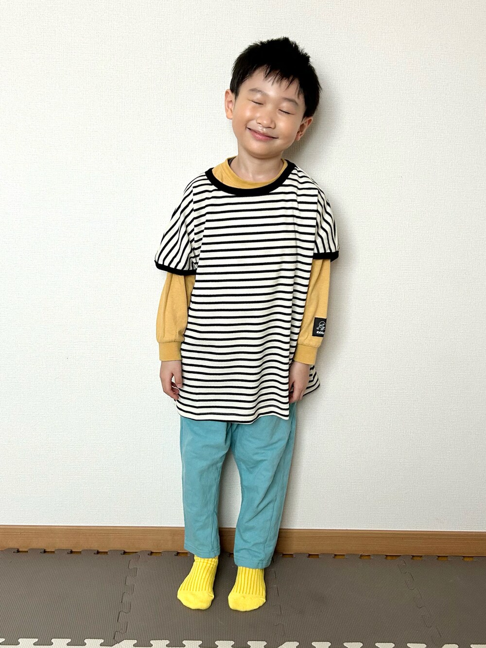 ホワイト系のセットアップ、ブルー系のその他パンツ、イエロー系のTシャツ/カットソーを着用したキッズの春コーディネートの4枚目の写真