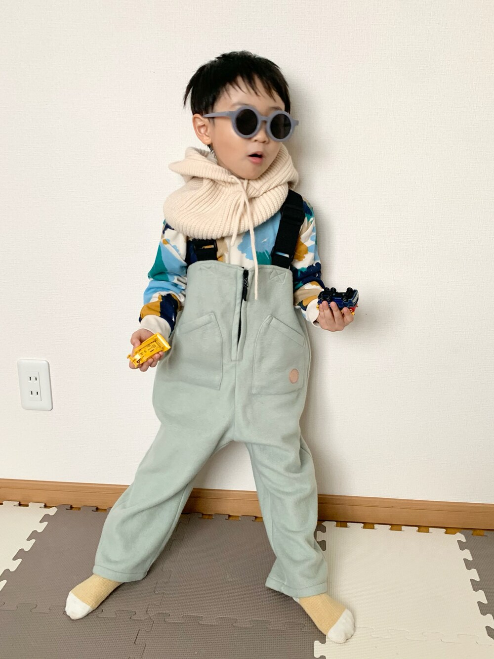 グリーン系のサロペット/オーバーオール、その他のスウェット、ホワイト系のネックウォーマー/スヌードを着用したキッズの冬コーディネートの3枚目の写真