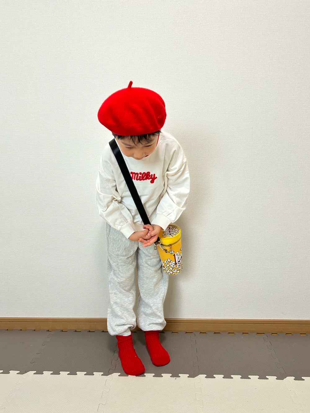 グレー系のスウェットパンツ、ホワイト系のスウェット、イエロー系のショルダーバッグを着用したキッズの秋コーディネートの4枚目の写真