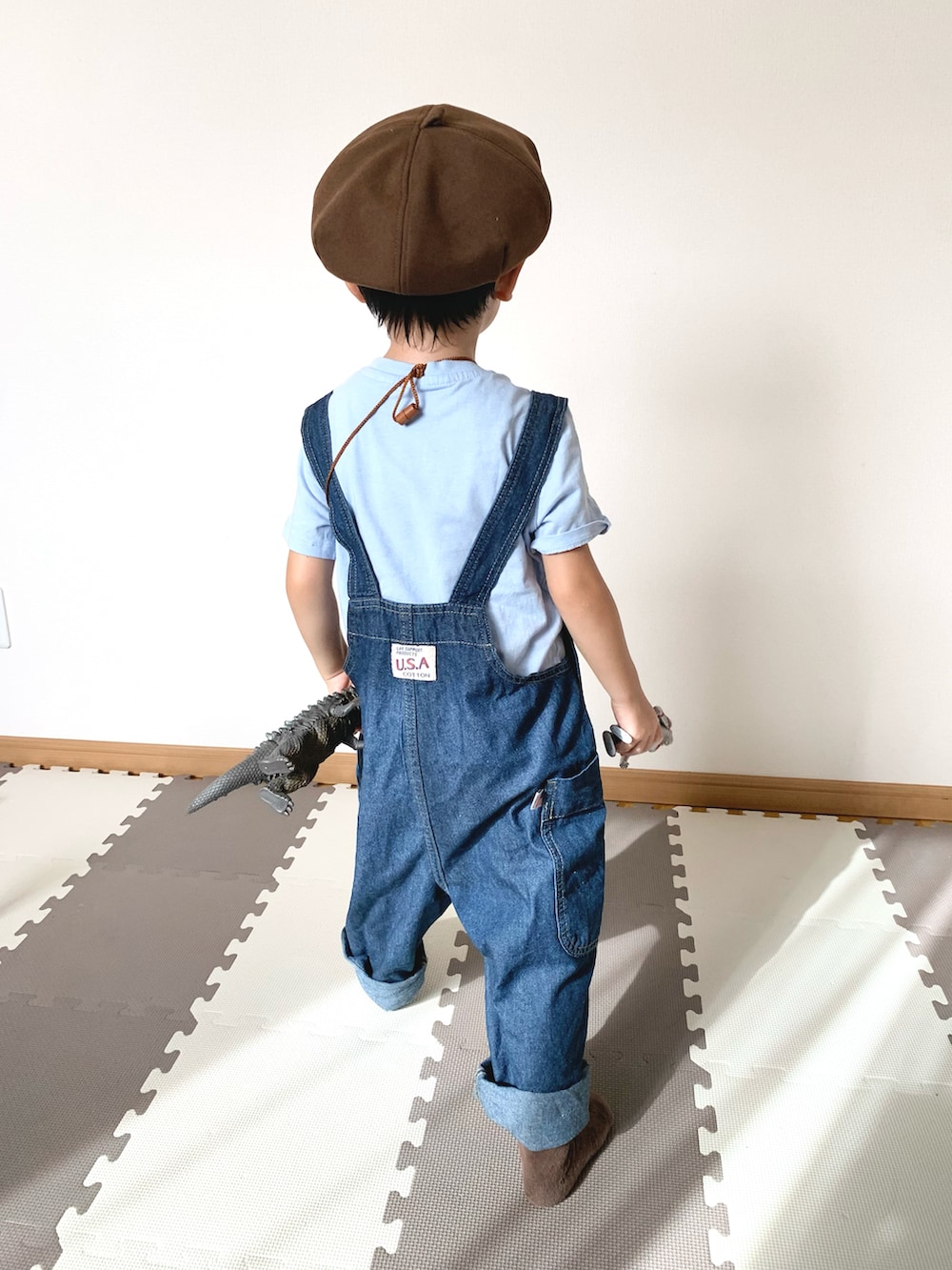 ブルー系のサロペット/オーバーオール、ブラウン系のショルダーバッグ、ブルー系のTシャツ/カットソーを着用したキッズの秋コーディネートの4枚目の写真