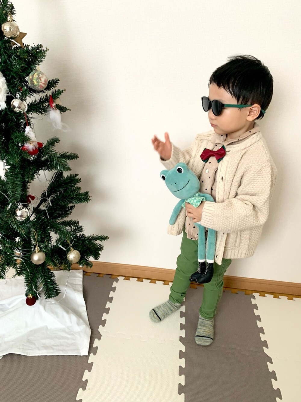 グリーン系のデニムパンツ、ベージュ系のカーディガン/ボレロ、ベージュ系のシャツ/ブラウスを着用したキッズの冬コーディネートの2枚目の写真