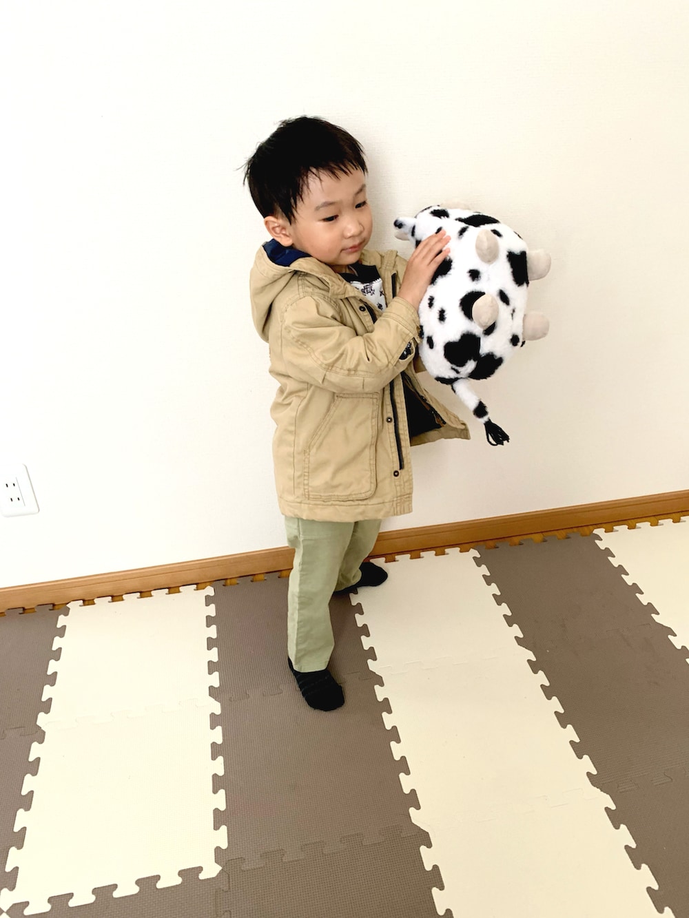 ブルー系のスウェット、ベージュ系のミリタリージャケット、グリーン系のチノパンツを着用したキッズの冬コーディネートの3枚目の写真