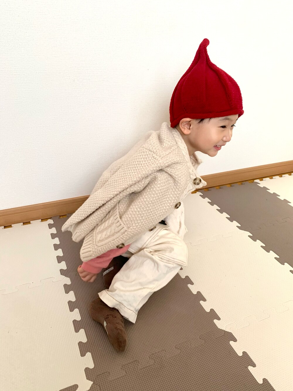 ピンク系のTシャツ/カットソー、ホワイト系のサロペット/オーバーオール、ベージュ系のカーディガン/ボレロを着用したキッズの冬コーディネートの4枚目の写真