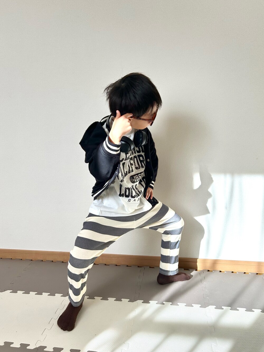 グレー系のその他パンツ、ホワイト系のTシャツ/カットソー、ブラック系のジャケット/アウターを着用したキッズの秋コーディネートの4枚目の写真