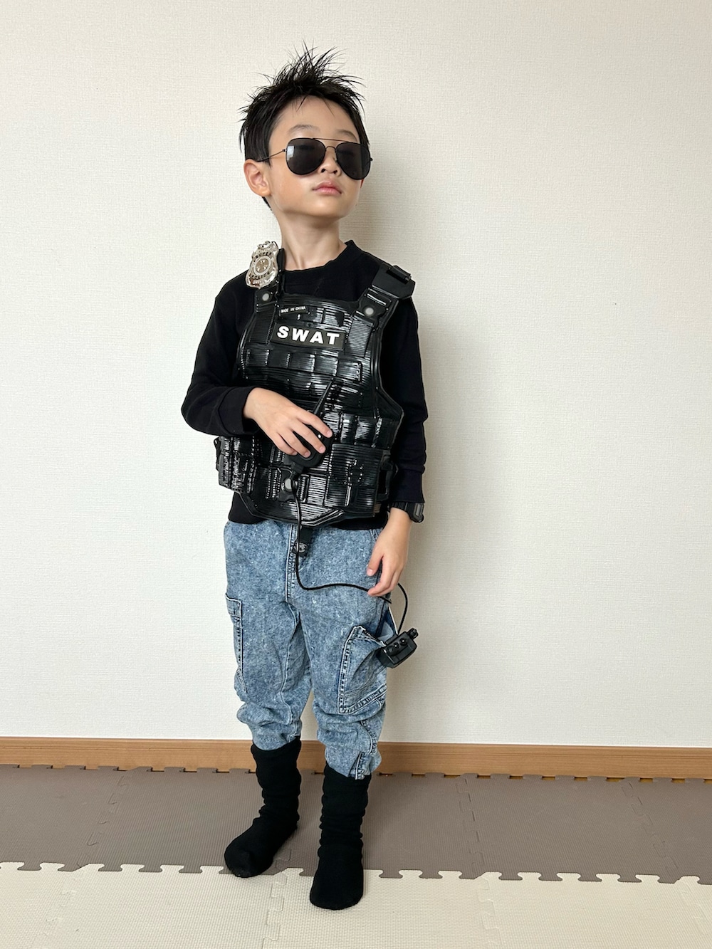 ブラック系のスウェット、ブルー系のパンツ、ブラック系のサングラスを着用したキッズの秋コーディネートの3枚目の写真