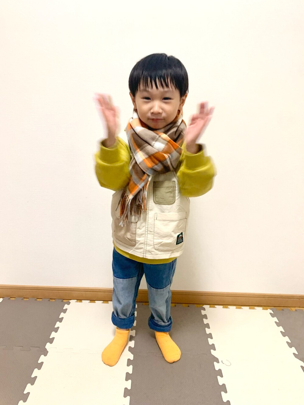 イエロー系のパーカー、ブルー系のデニムパンツ、その他のソックス/靴下を着用したキッズの秋コーディネートの3枚目の写真